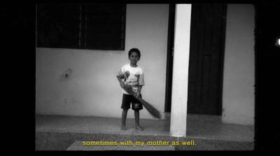 a young boy holding a bat standing in front of a building