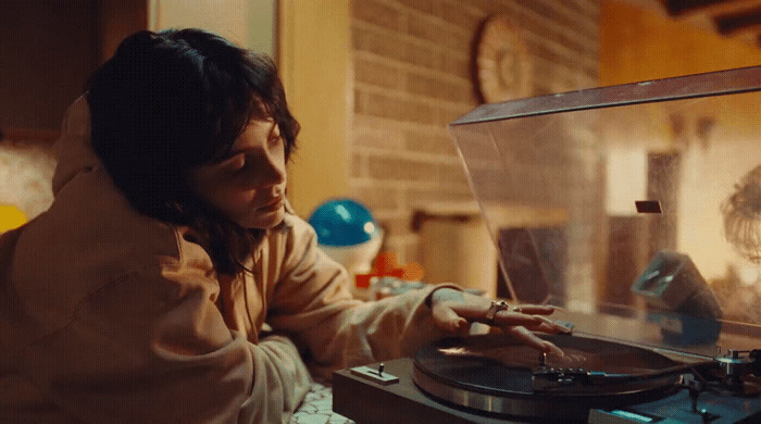 a woman sitting at a record player in a room