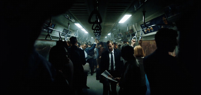 a group of people standing in a subway car