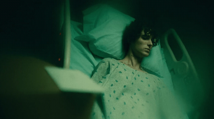 a man laying in a hospital bed in a green light