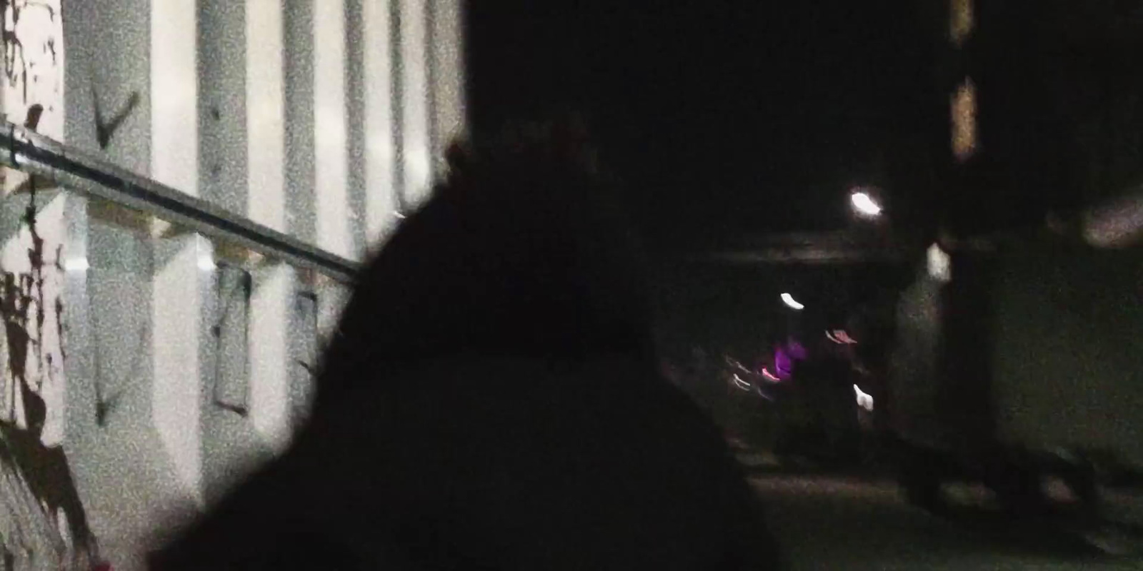 a blurry photo of a person walking down a street at night