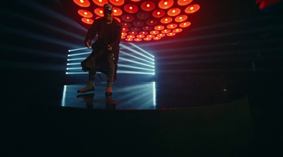 a man standing on top of a stage in front of a red light