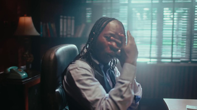 a man sitting in a chair with his hands on his face