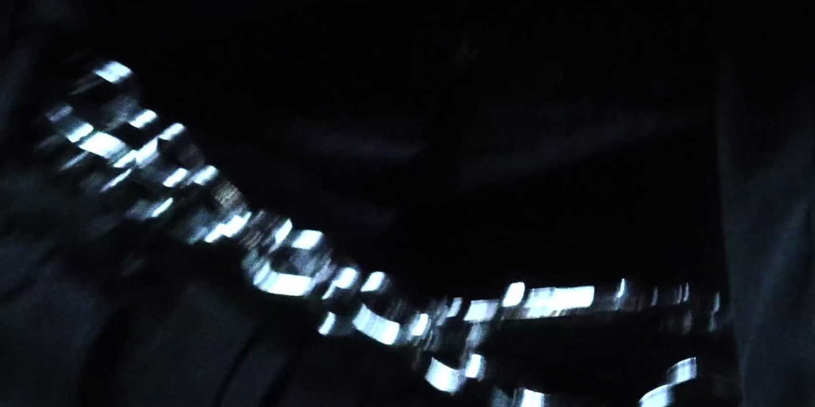 a blurry photo of a person's belt in the dark