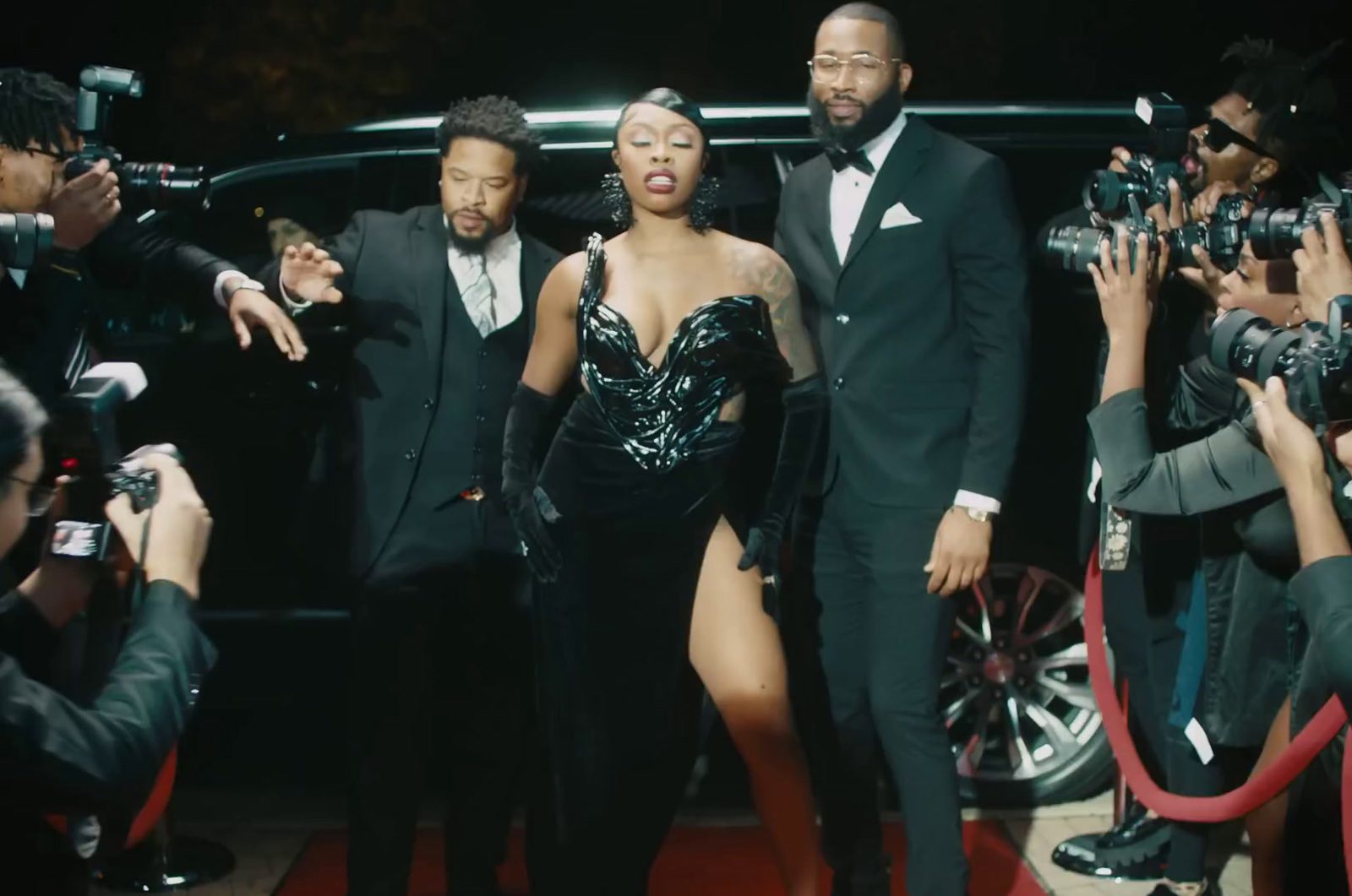 a group of people that are standing in front of a car