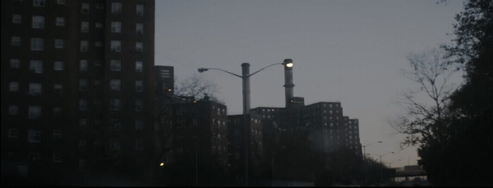 a city street with tall buildings and street lights