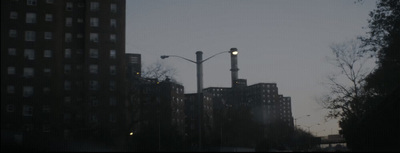 a city street with tall buildings and street lights