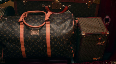 a brown louis vuitton bag sitting next to a brown louis vuitton