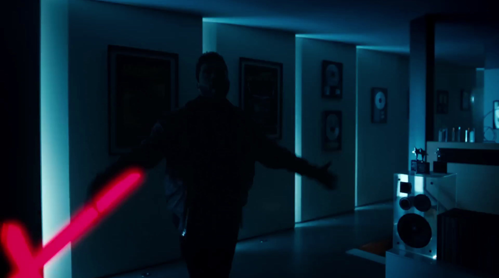 a man in a dark room holding a red light saber