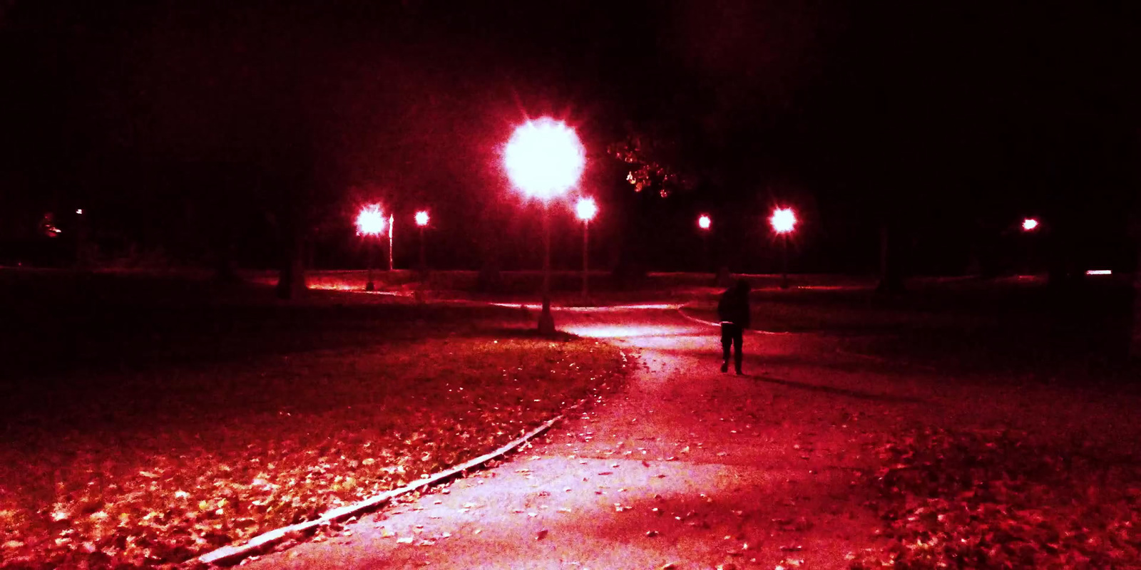 a person walking down a street at night