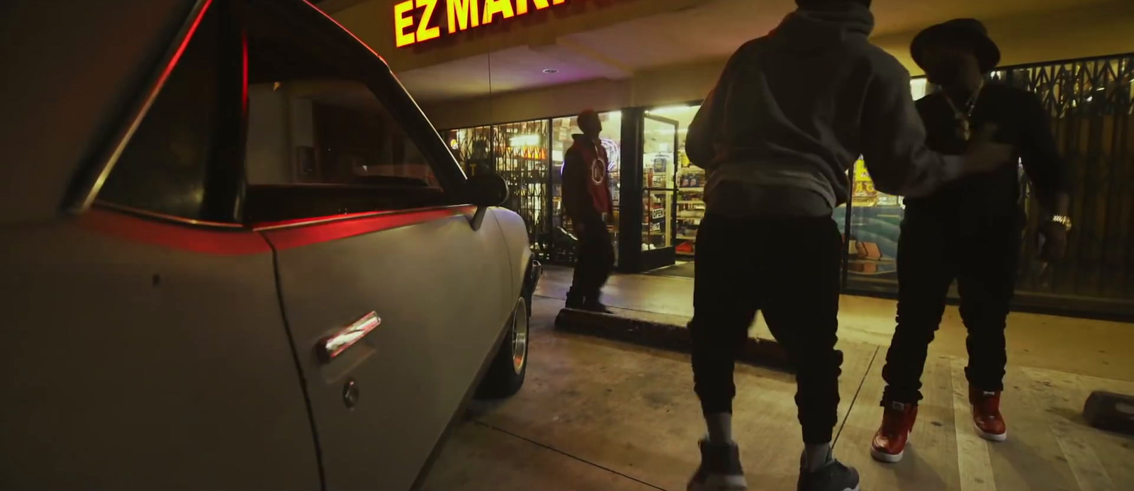 a couple of people standing in front of a car