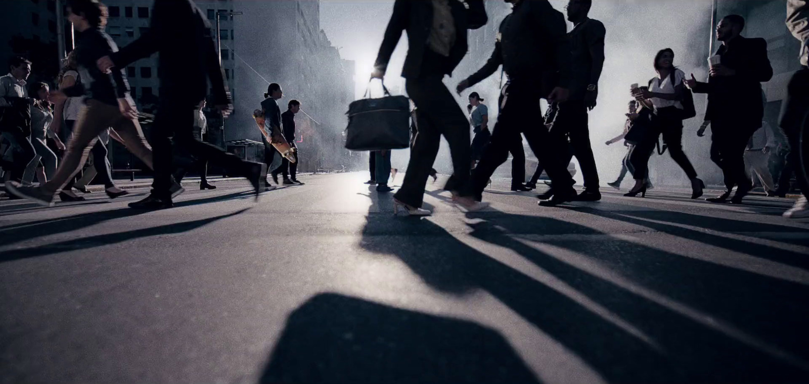 a group of people walking down a street next to tall buildings