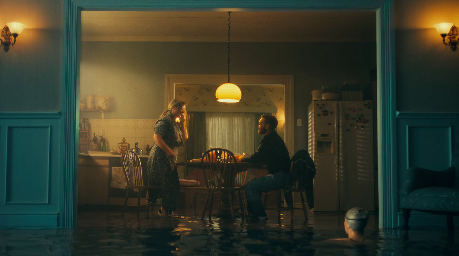 a couple of women sitting at a table in a kitchen