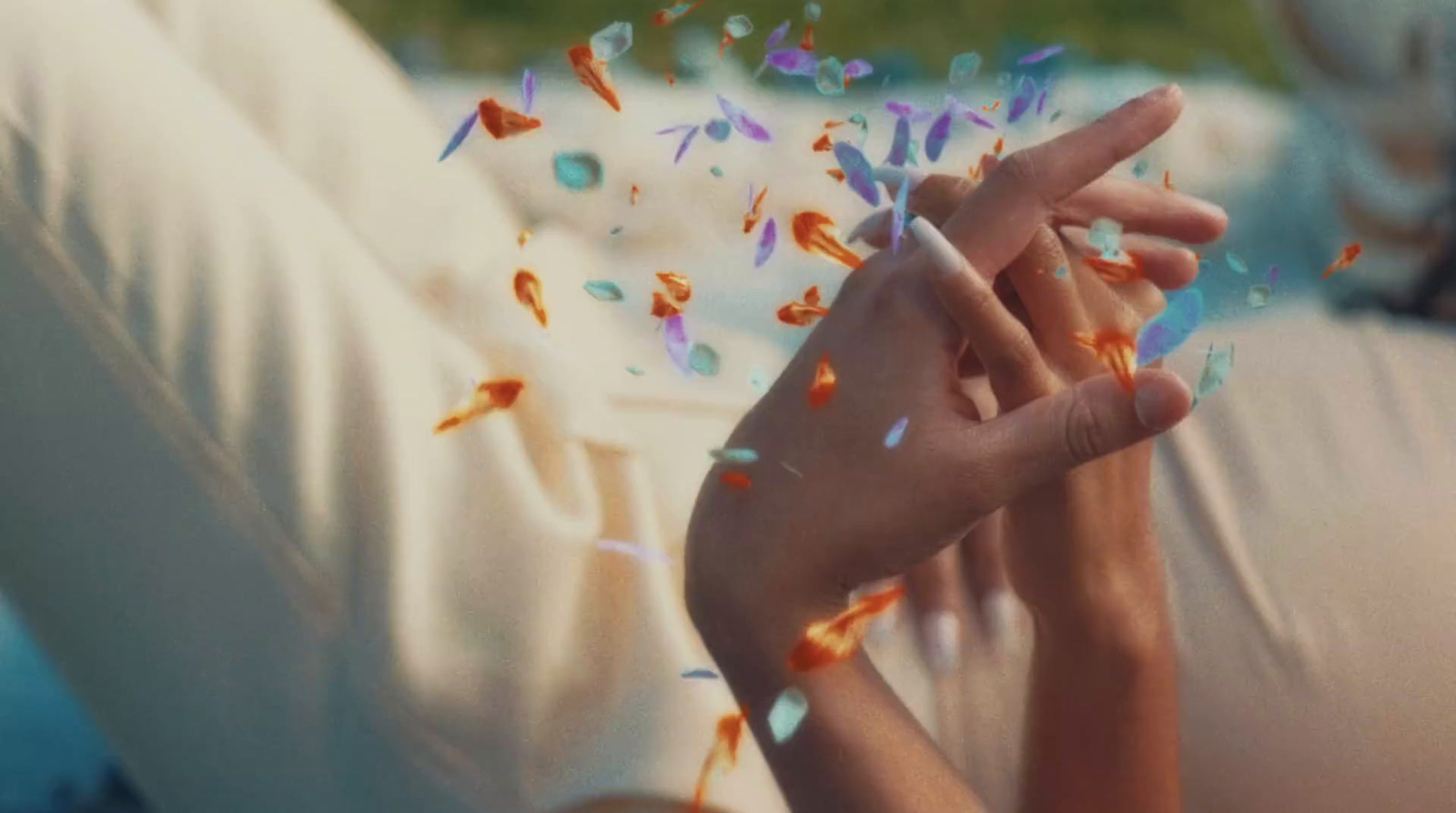 a woman laying on a bed with confetti falling from her hands