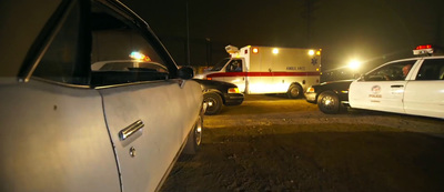 two ambulances parked in a parking lot at night