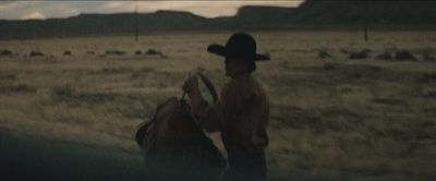 a man in a cowboy hat standing next to a horse