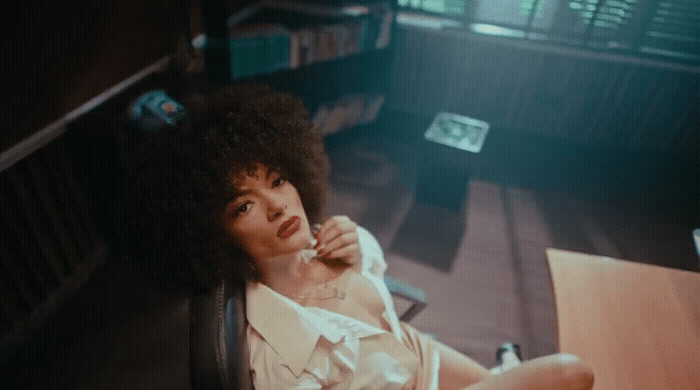 a woman sitting at a desk with a pen in her hand