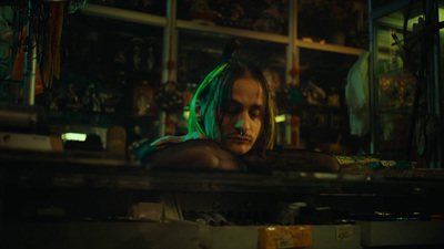 a man with green hair sitting in a room