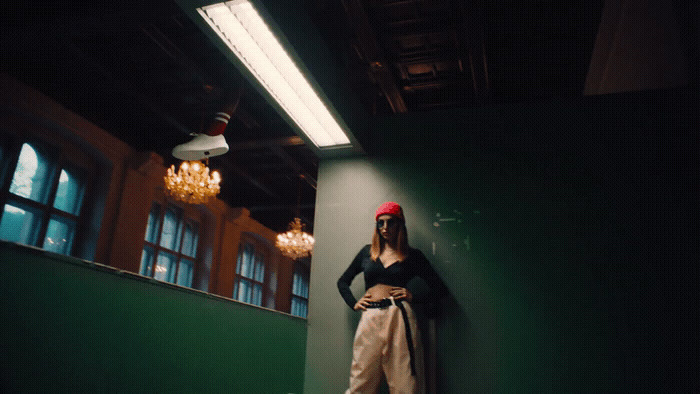 a woman leaning against a green wall in a room