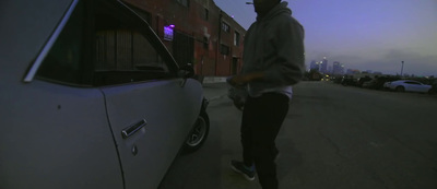 a man standing next to a car on a street