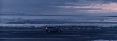 a truck driving down a road in the snow