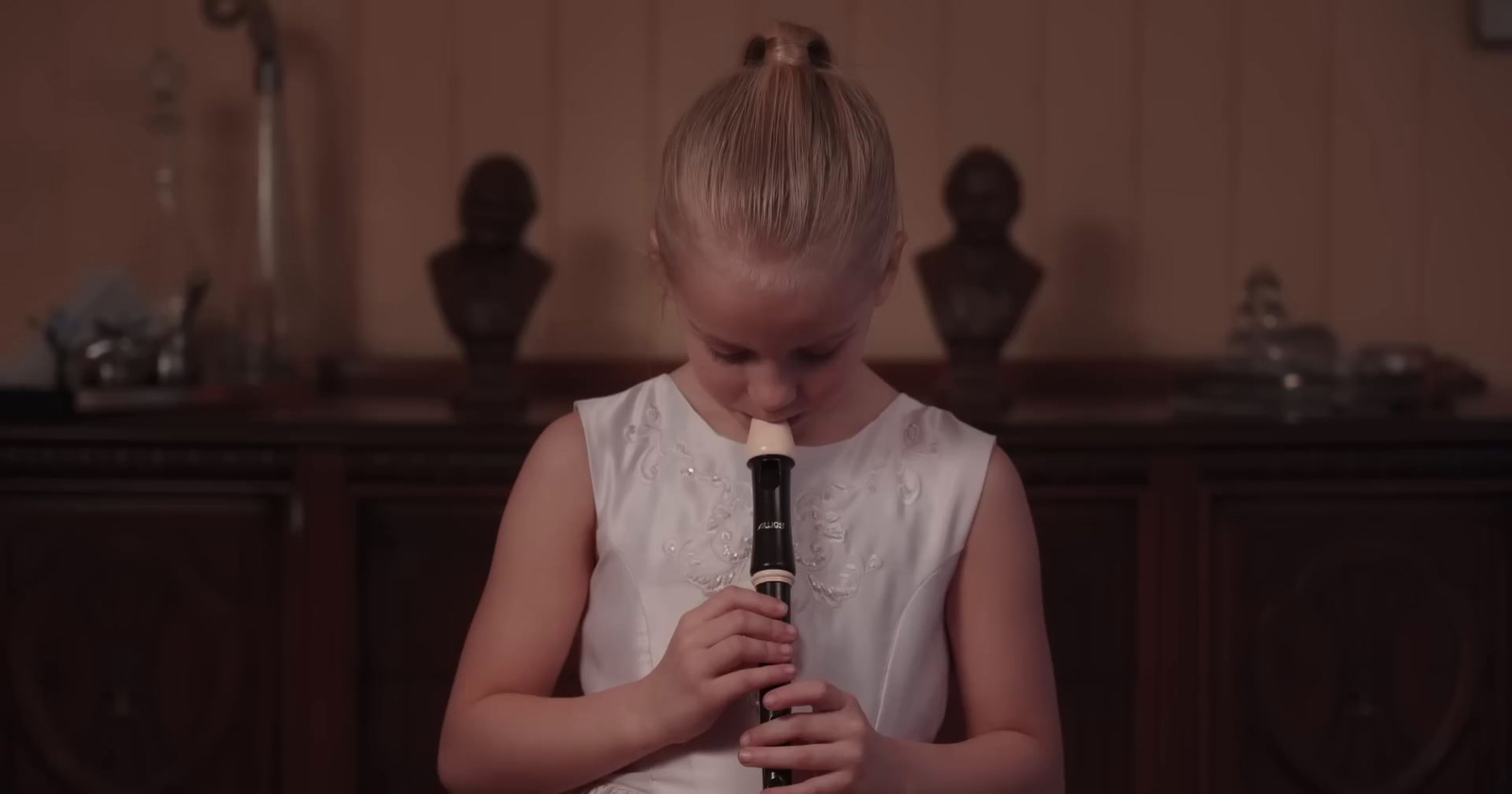 a young girl holding a recorder in her hands