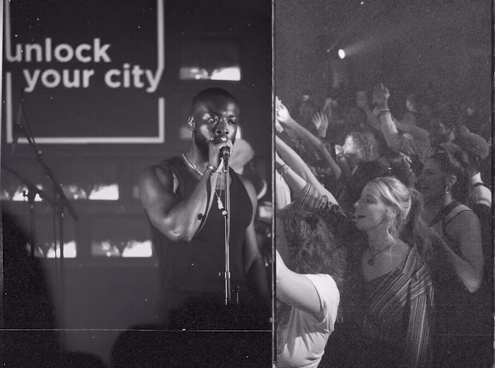 a man standing in front of a microphone in front of a crowd