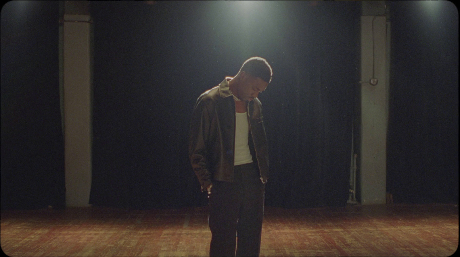 a man standing in a dark room with a light on