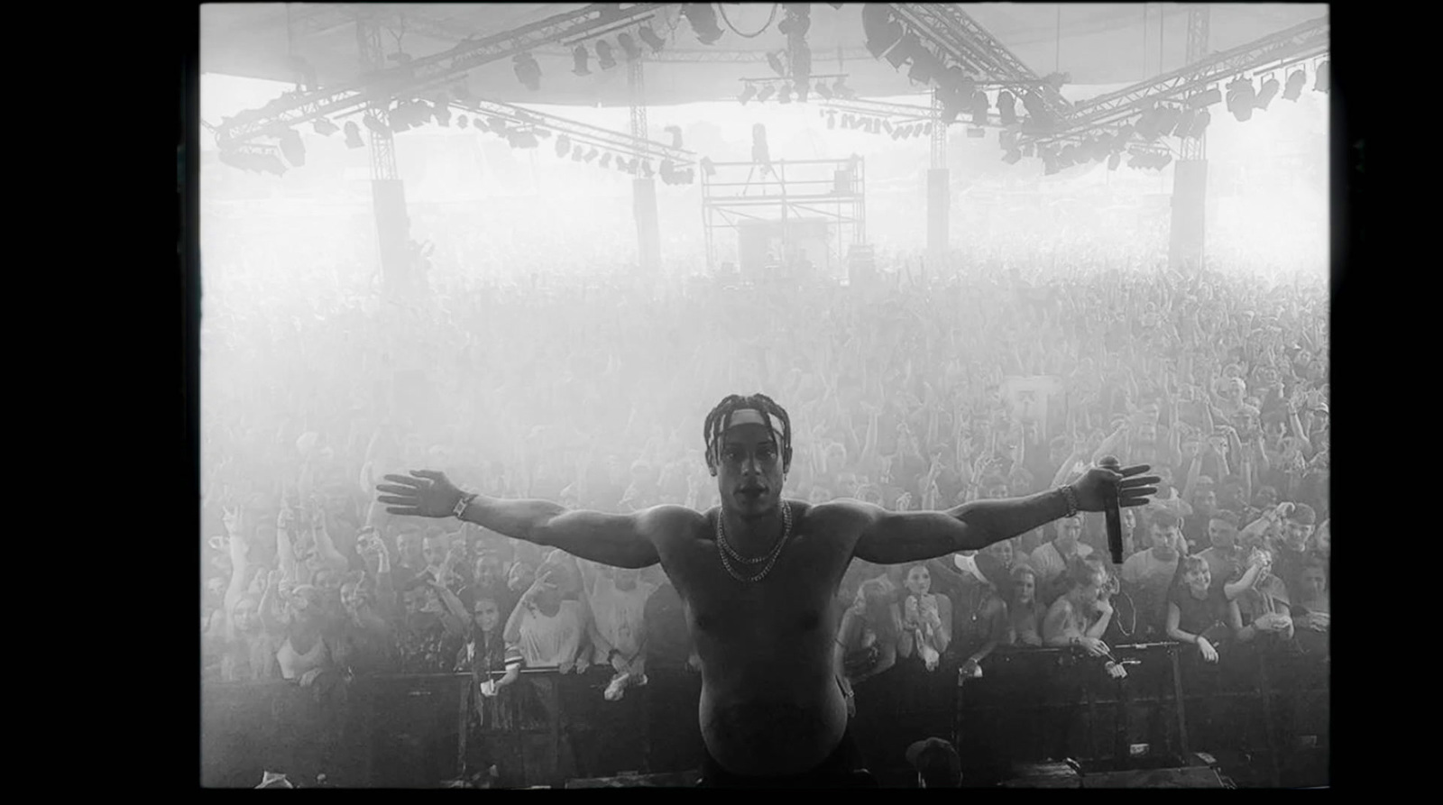 a shirtless man standing in front of a crowd