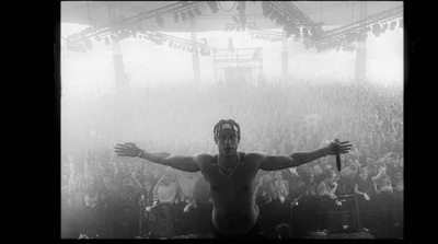 a shirtless man standing in front of a crowd