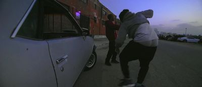 a man riding a skateboard down a street next to a car