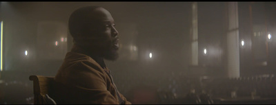 a man sitting in a chair in a dark room