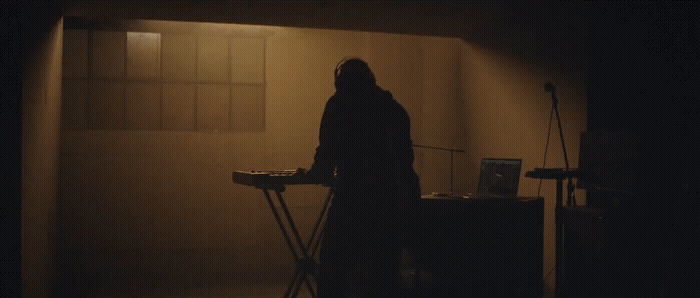 a person standing in a dark room with a mixer