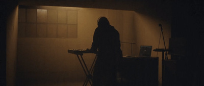 a person standing in a dark room with a mixer