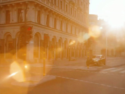 a car driving down a street next to a tall building