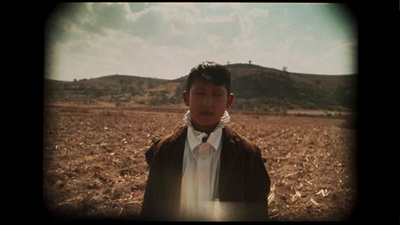 a person standing in a field with a sky background