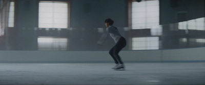 a woman skating on an ice rink in a building