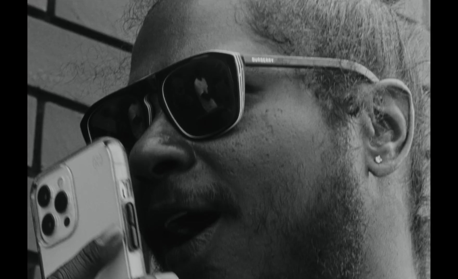 a man with sunglasses talking on a cell phone