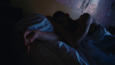 a man laying in bed with his hands on the pillow