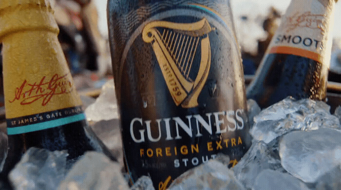 two bottles of beer sitting on top of ice