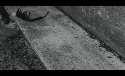 a black and white photo of a shoe on the ground