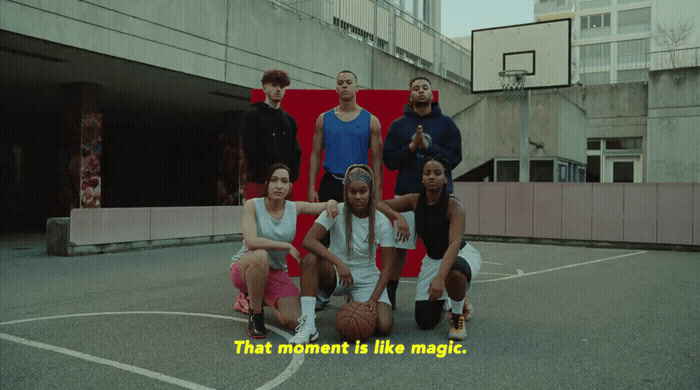 a group of young people sitting on top of a basketball court