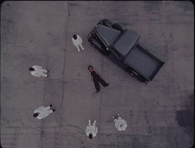 a group of people laying on the ground next to a car