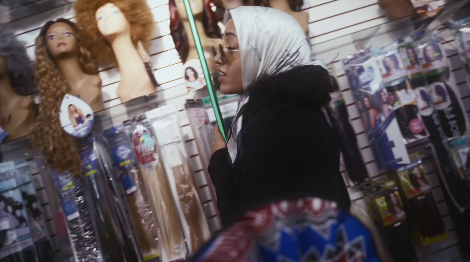 a woman standing in front of a wall of mannequins