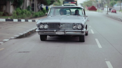 a car driving down a street next to a street sign