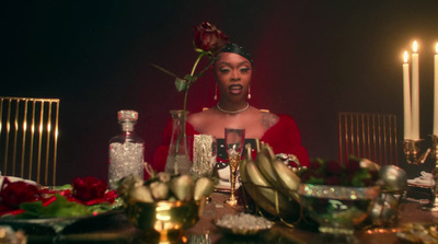 a woman sitting at a table with a rose in her hair