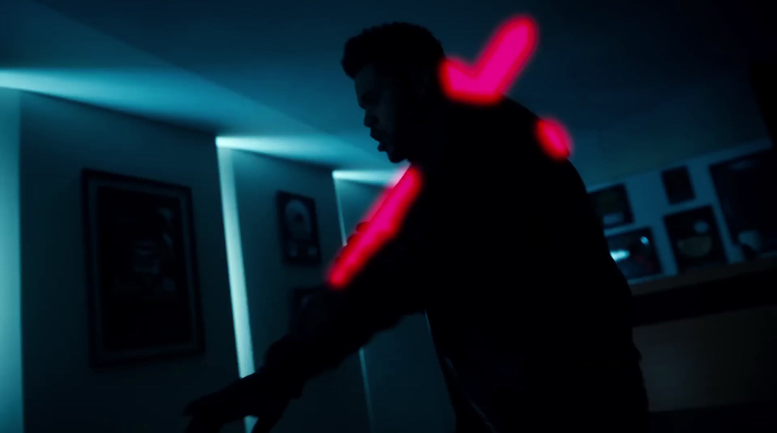 a man standing in a dark room holding a red object