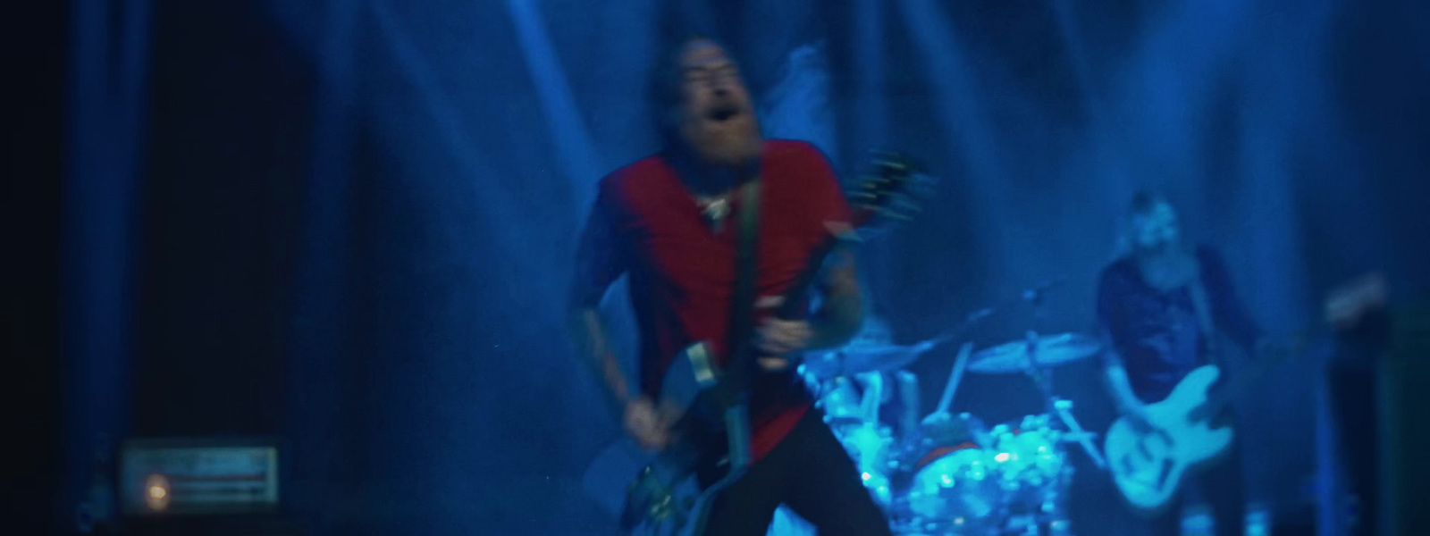 a man standing on a stage with a guitar