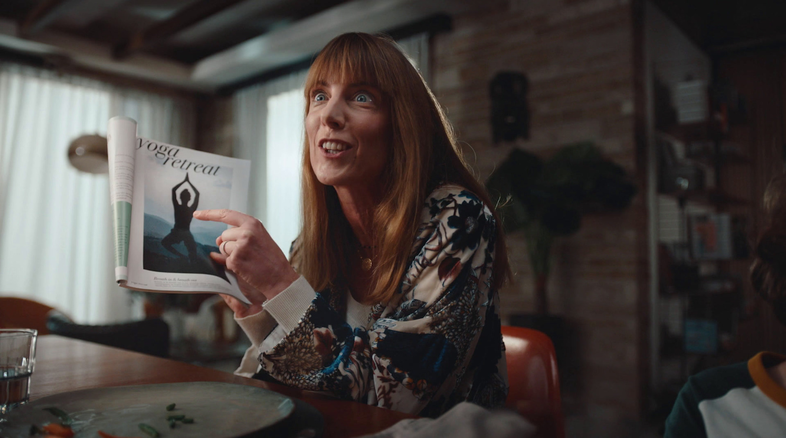 a woman sitting at a table reading a book