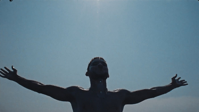 a man with his arms outstretched in front of a blue sky